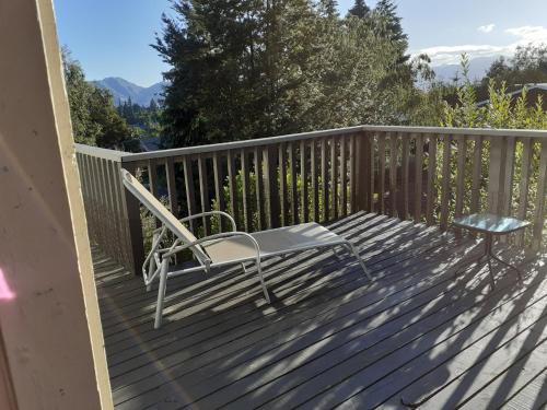a deck with a chair and a bench on it at 9 Alpine Avenue in Hanmer Springs