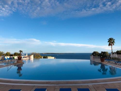 une grande piscine avec vue sur l'océan dans l'établissement T2 clim-terrasse plein sud vue mer, à Cannes
