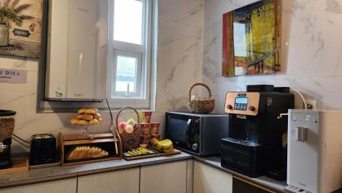 - une cuisine avec un comptoir et un four micro-ondes dans l'établissement Gimhae Business Hotel K, à Gimhae