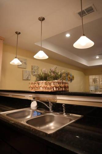 a kitchen counter with a sink and three lights at Mirror, mirror on the wall! in McAllen