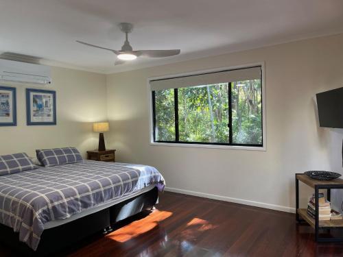 Un dormitorio con una cama y una ventana grande. en 8 Orania Court Rainbow Shores, en Rainbow Beach