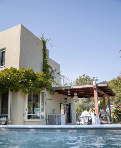 a house with a swimming pool in front of a house at Ettys Villa in Giv'at Yo'av