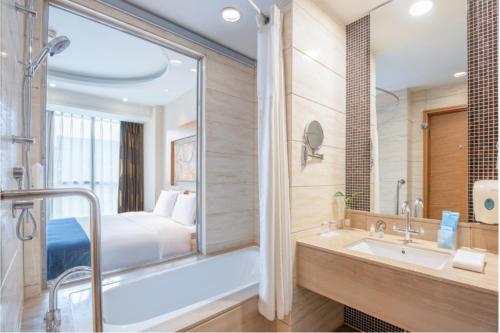 un bagno con vasca, lavandino e letto di Holiday Inn Express Beijing Huacai, an IHG Hotel a Pechino