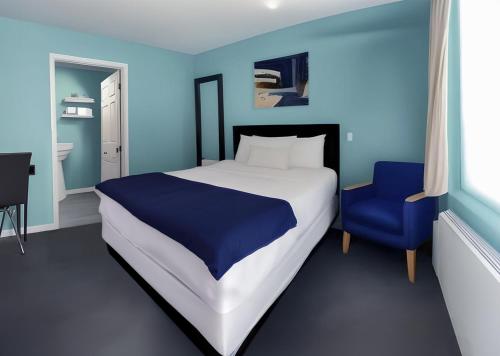 ein blaues Schlafzimmer mit einem Bett und einem blauen Stuhl in der Unterkunft Granby Motel in South Hadley