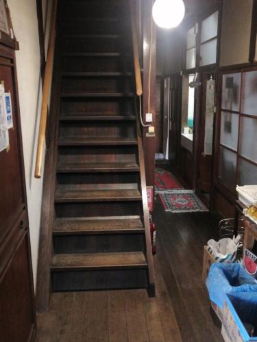 a staircase in a room with wooden floors at c Historical Tea Celemony House 〜 old, dirty, not hotel in Kaneyoshi