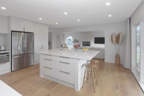 a kitchen with a white island and a refrigerator at Carterley House in Christchurch