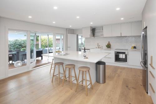 a kitchen with a large white island with bar stools at Carterley House in Christchurch
