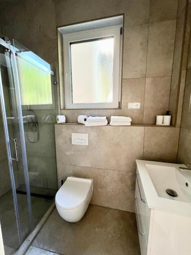 a bathroom with a toilet and a sink and a window at Suite One Langestr II in Varel