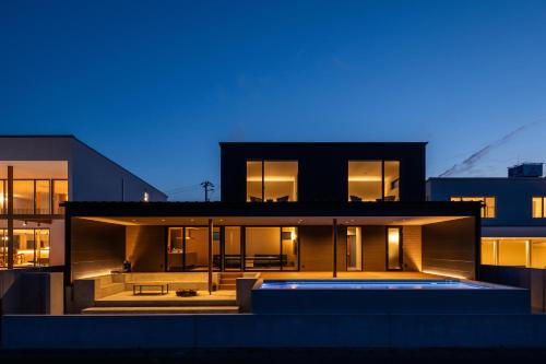 a house with a swimming pool in front of it at SETO CLAS TSUDA THE Beach RESORT B in Yoshimi