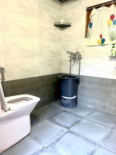 a bathroom with a toilet and a bucket at The Heavens Place in Nagar