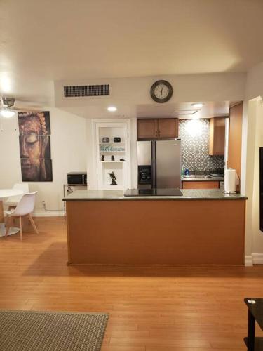 a large kitchen with a counter and a clock on the wall at Centrally located to Strip, UNLV, Stadiums and so much more! in Las Vegas