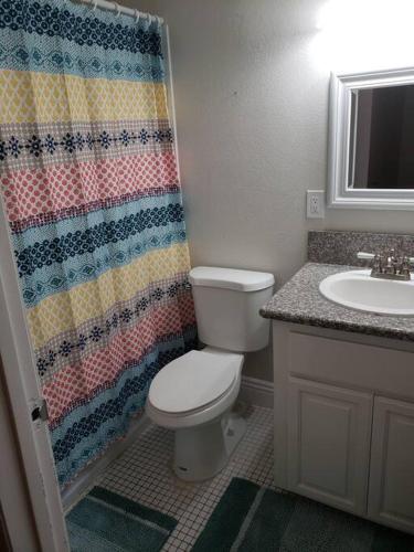 a bathroom with a toilet and a shower curtain at Centrally located to Strip, UNLV, Stadiums and so much more! in Las Vegas