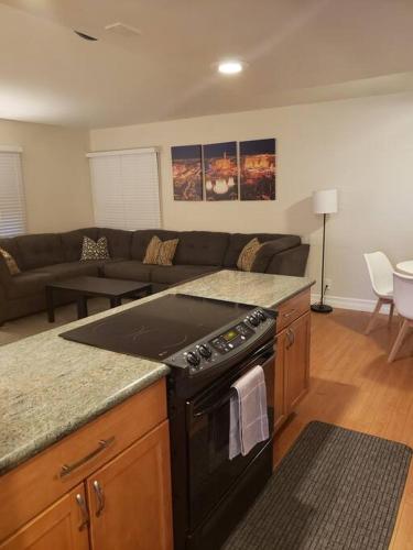 a kitchen with a stove and a living room at Centrally located to Strip, UNLV, Stadiums and so much more! in Las Vegas