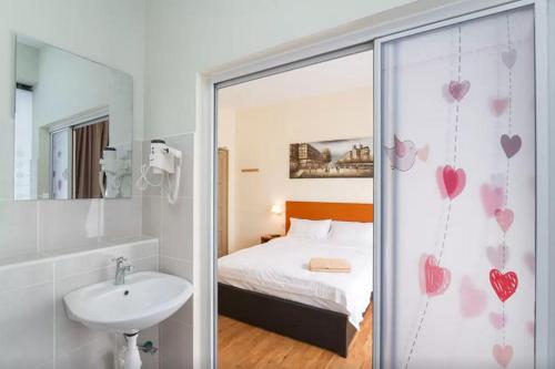 a bathroom with a bed and a sink and a mirror at Penang Hill Lodge in Ayer Itam