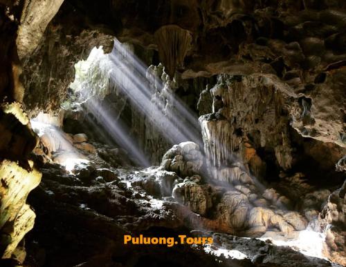 a waterfall in a cave with water flowing through it at PU LUONG BOUTIQUE GARDEN in Pu Luong