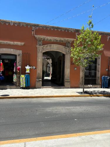 een oranje gebouw met een boog op een straat bij Hotel Boutique Casona los Pavorreales in Durango