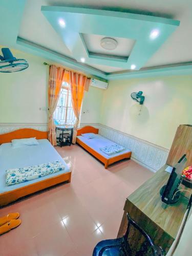 Un dormitorio con dos camas y una ventana. en Phạm Gia Hotel HG - by BAY LUXURY, en Ha Giang