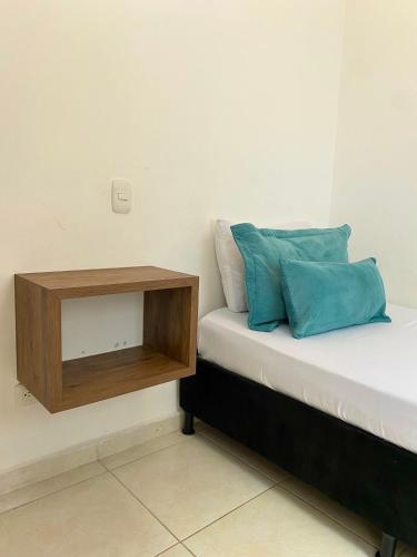a small bed with a wooden night stand next to it at Apartamento con Piscina en Dosquebradas in Dosquebradas