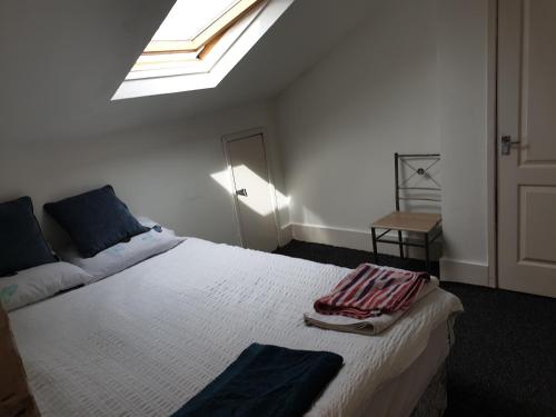 1 dormitorio con 1 cama blanca grande y tragaluz en Townsend Studio/Rooms en Liverpool