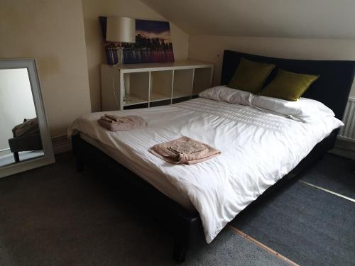 une chambre avec un grand lit avec deux serviettes dessus dans l'établissement Townsend Studio/Rooms, à Liverpool