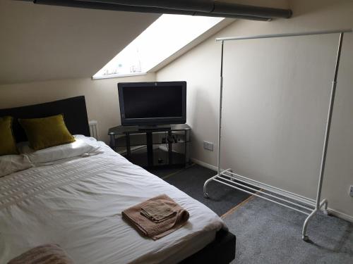 une chambre avec un lit et une télévision à écran plat dans l'établissement Townsend Studio/Rooms, à Liverpool