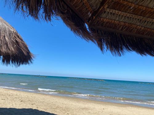 a beach with a straw umbrella and the ocean at WestHouse in Pescara