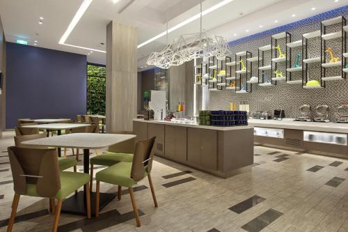 a restaurant with a table and chairs and a kitchen at Holiday Inn Express Jakarta Wahid Hasyim, an IHG Hotel in Jakarta