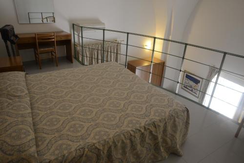 a bedroom with a bed and a table and a desk at Albergo Italia in Matera