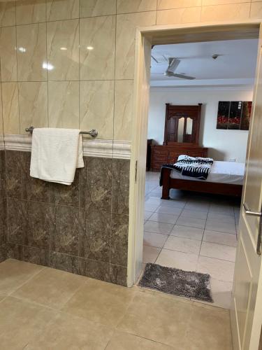 een badkamer met een inloopdouche naast een bed bij FINE HOMES MIKOCHENI in Dar es Salaam
