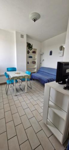 Cette chambre comprend un lit, une table et un bureau. dans l'établissement Studio - Marina 4 - 13 allée des Pinons 8-1, à Saint-Jean-de-Monts