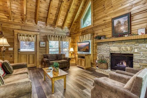 uma sala de estar com uma lareira de pedra num chalé de madeira em ER215 - Red Bird Haven cabin em Pigeon Forge