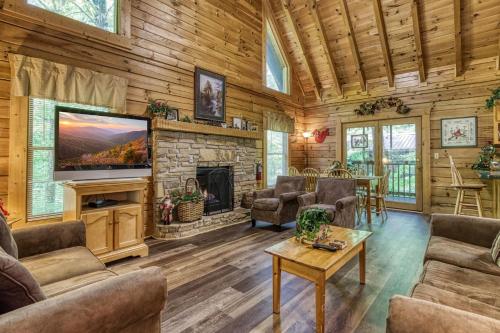 uma sala de estar com lareira e televisão em ER215 - Red Bird Haven cabin em Pigeon Forge