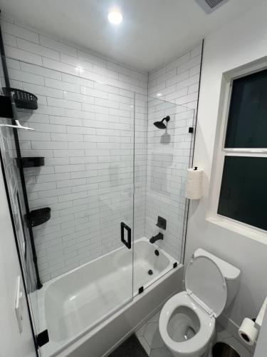 y baño blanco con aseo y ducha. en 1BR Hollywood Townhouse en Los Ángeles