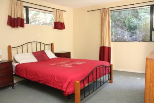 Un dormitorio con una cama con una manta roja. en 45 Alpine Avenue, en Hanmer Springs