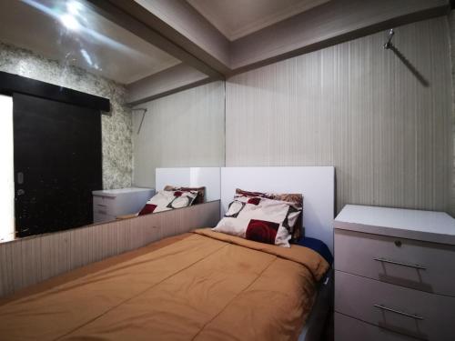 Dormitorio pequeño con cama y espejo en Raja Apartemen Jarrdin Type 33 en Bandung
