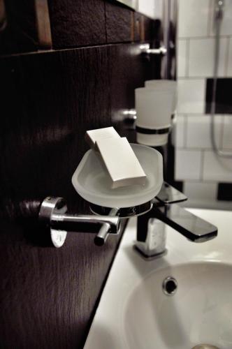 a bathroom with a sink with a book on it at Hotel Klondaik Corner in Warka