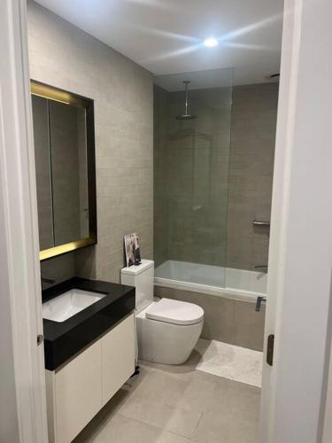 Un baño con inodoro, lavabo y bañera. en Lakeside 3 Bedroom home., en Melbourne