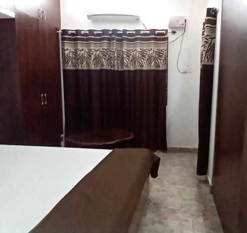La salle de bains est pourvue d'un rideau de douche noir et de toilettes. dans l'établissement Basera, à Port Blair