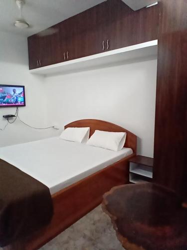 une chambre avec un lit et une télévision au mur dans l'établissement Basera, à Port Blair
