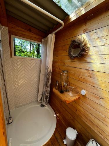 a bathroom with a white tub in a wooden cabin at Glamping U Lesa in Rychnov nad Kněžnou