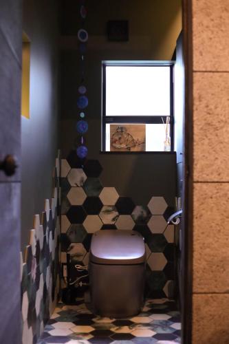 a bathroom with a toilet and a window at ＩＲＡＧＯ　ＡＲＴ　 ＨＯＴＥＬ 　THECAPE in Irago
