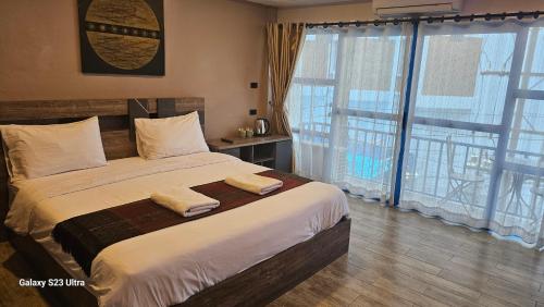 a bedroom with a large bed with two towels on it at Central Guesthouse Chiang Rai - Bread & Breakfast in Chiang Rai