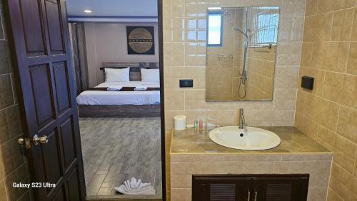 a bathroom with a sink and a shower and a bed at Central Guesthouse Bread & Breakfast in Chiang Rai