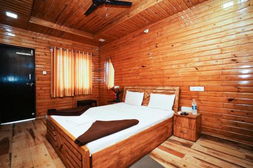 a bedroom with a bed in a wooden cabin at Sunshine Resort in Pune
