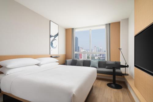 Habitación de hotel con cama y sofá en Fairfield by Marriott Hangzhou Wulin Square, China, en Hangzhou