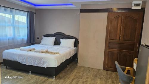 a bedroom with a bed with two towels on it at Central Guesthouse Chiang Rai - Bread & Breakfast in Chiang Rai