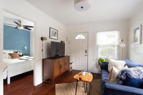 a living room with a blue couch and a bed at Stylish 2bed 2bath Culver Cottage with bicycles in Los Angeles