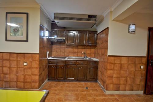 a kitchen with a sink and wooden cabinets at Private pool villa walking distance to the centre in Loulé