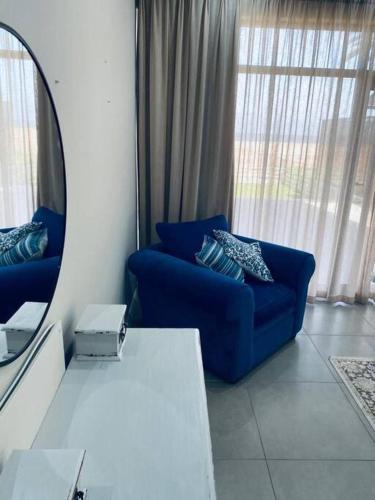 a living room with a blue couch and a mirror at Shametu @ Sea in Langstrand