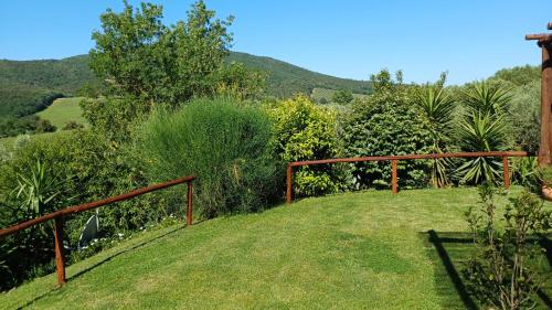 a garden with a fence and some bushes and trees at Agriturismo Colleverde Capalbio in Capalbio